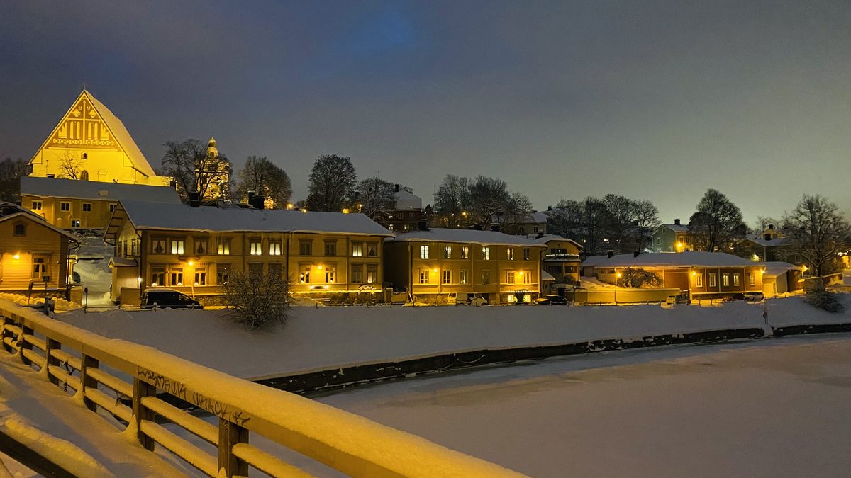 Porvoo old town at dusk in winter, wooden houses and the cathedral above the river