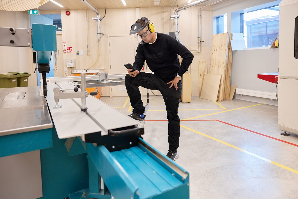 A user in a face shield and ear defenders unlocking a machine with the Bitwards app