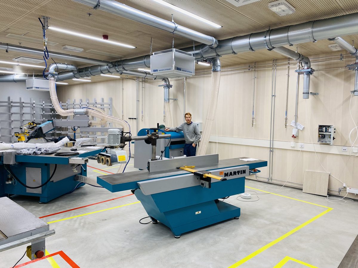 The department’s wood workshop, with a planer and a panel saw and floor markings around each machine